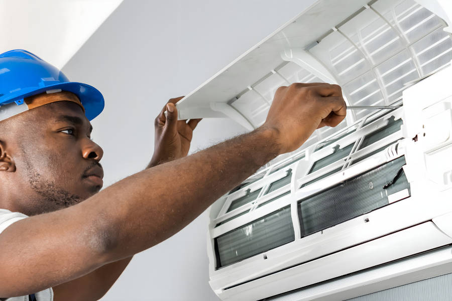 technicien nettoie un climatiseur à La Réunion 974